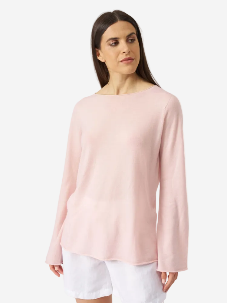 A woman wearing a pink cashmere round neck knit sweater with a wide neckline and relaxed fit.