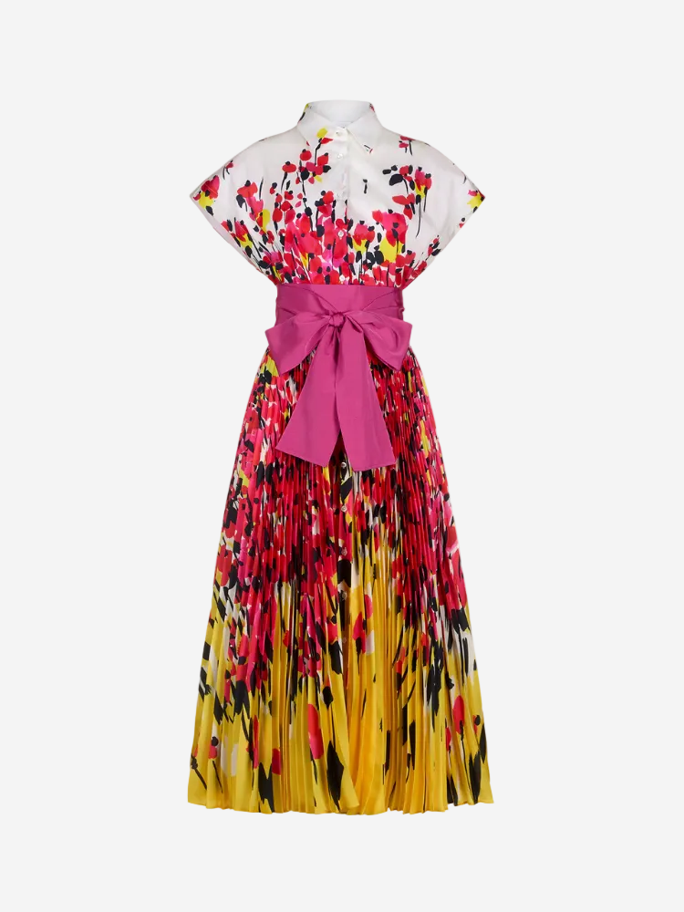 A pleated long dress with a floral pattern in shades of pink and yellow, featuring a pink belt at the waist.