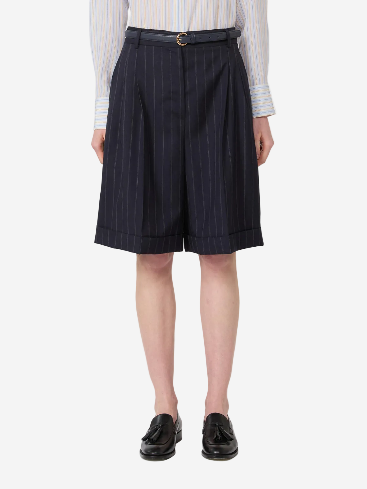 Person wearing navy pinstripe shorts with a white shirt on a white background