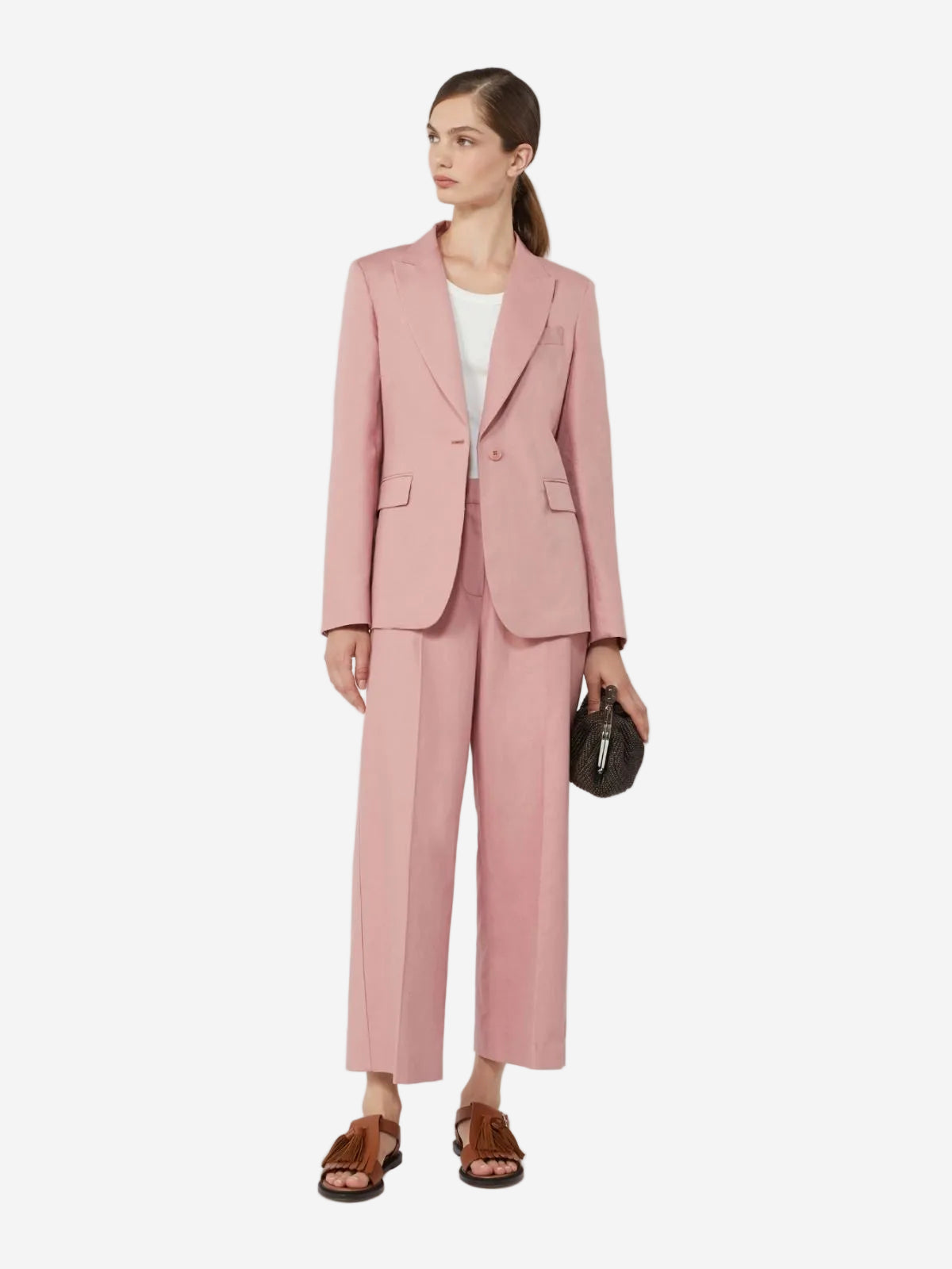 Woman wearing a pink suit with a white top on a light gray background