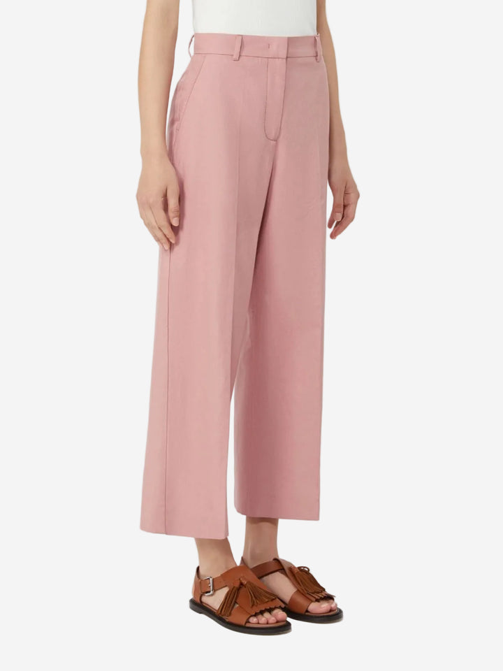 Person wearing pink pants and brown sandals on a white background