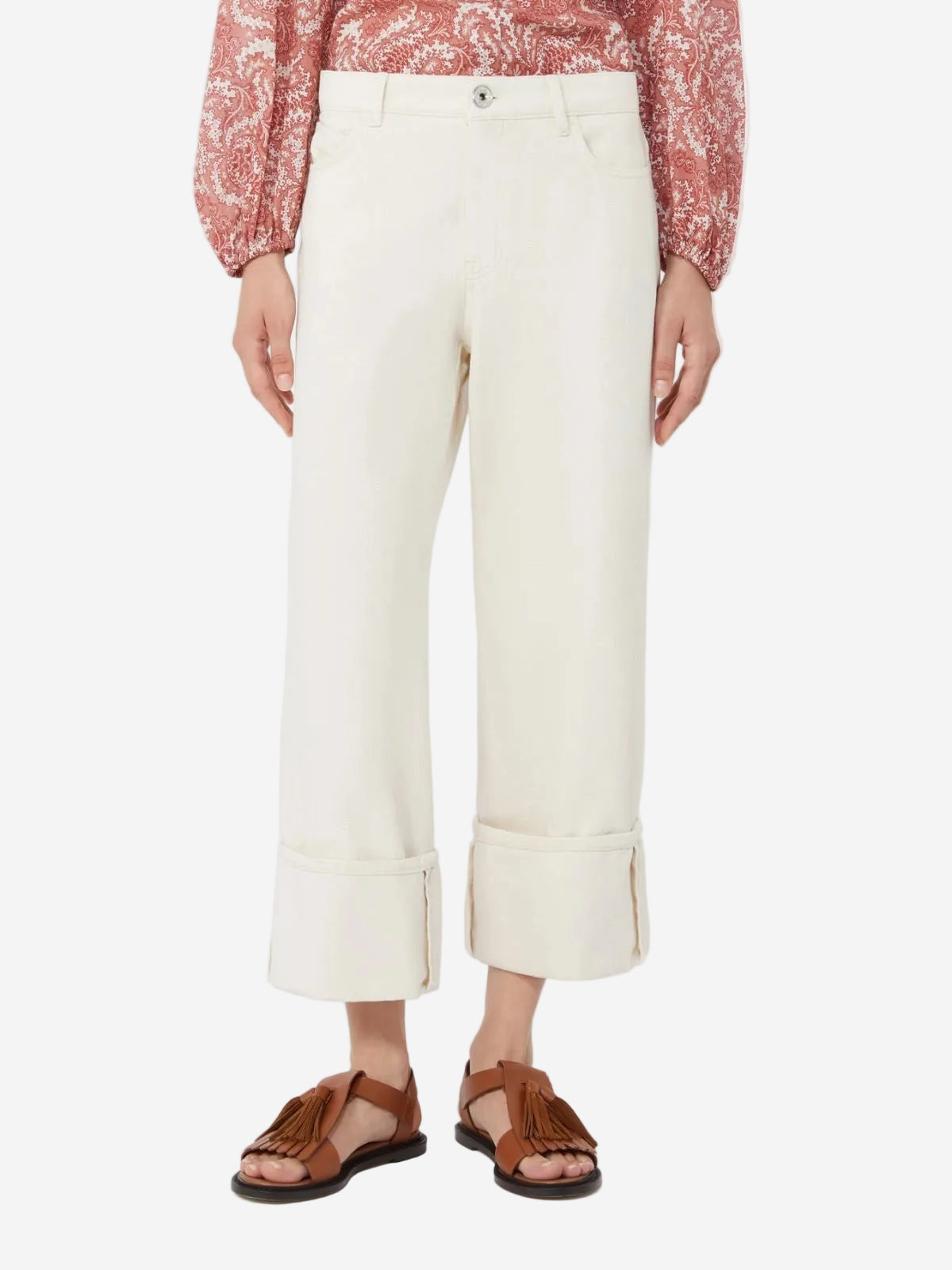 Person wearing white pants and brown sandals on a white background