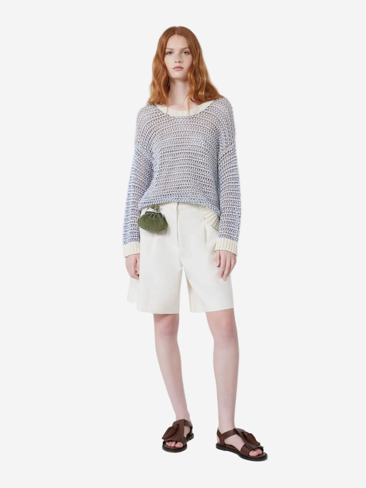 Woman wearing a patterned sweater and white shorts on a white background