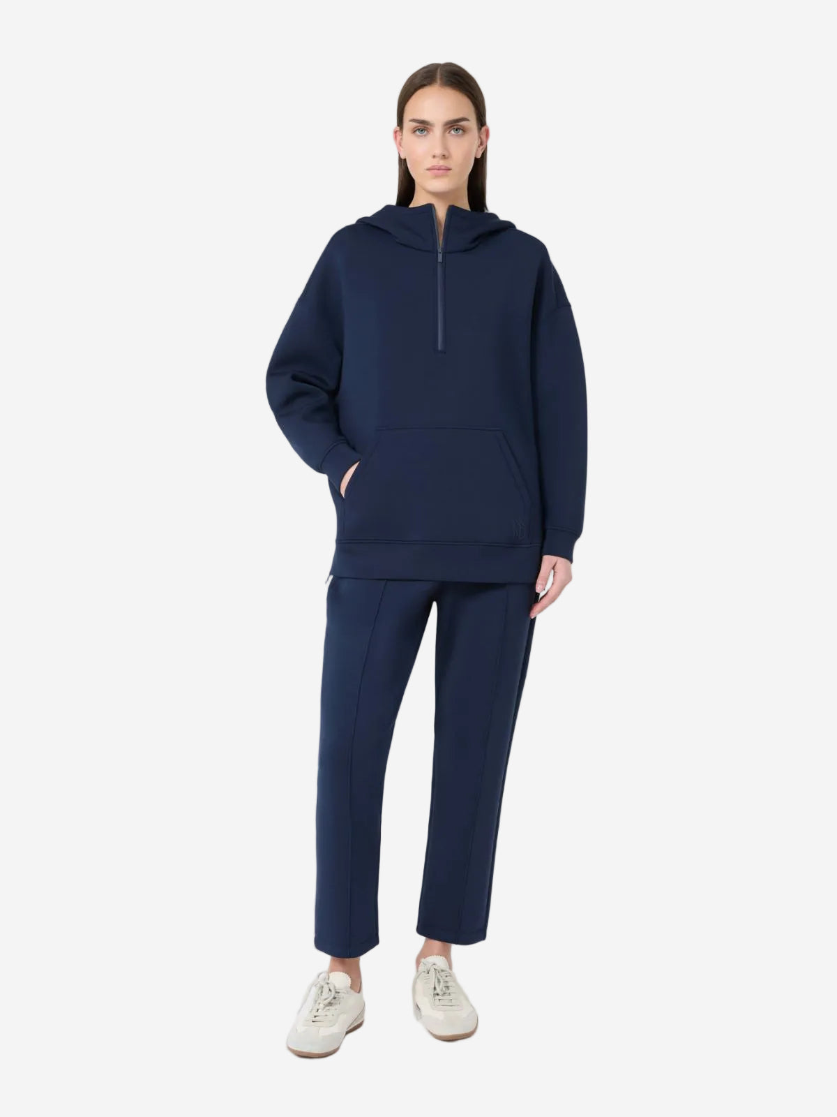 Person wearing a navy blue hoodie and pants on a white background