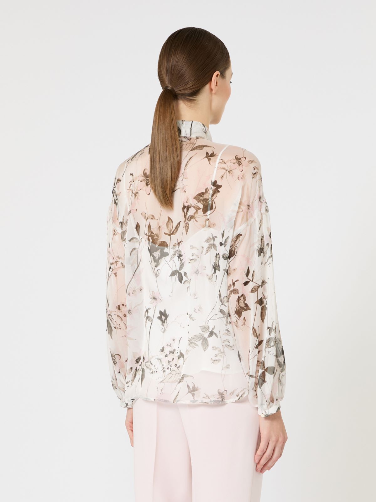 Woman wearing a floral blouse with a plain background