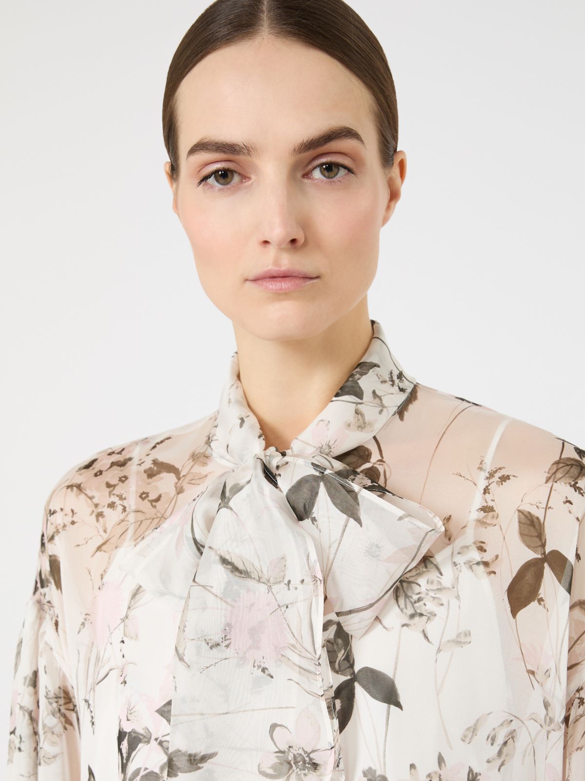 Woman wearing a floral blouse with a white background