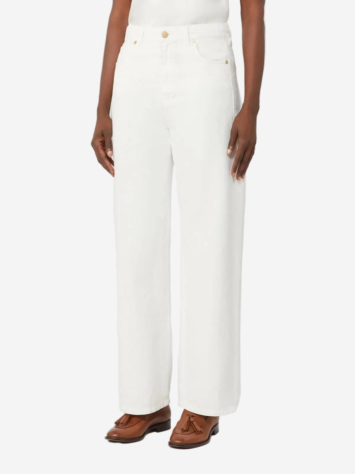 Person wearing white pants with brown shoes on a white background