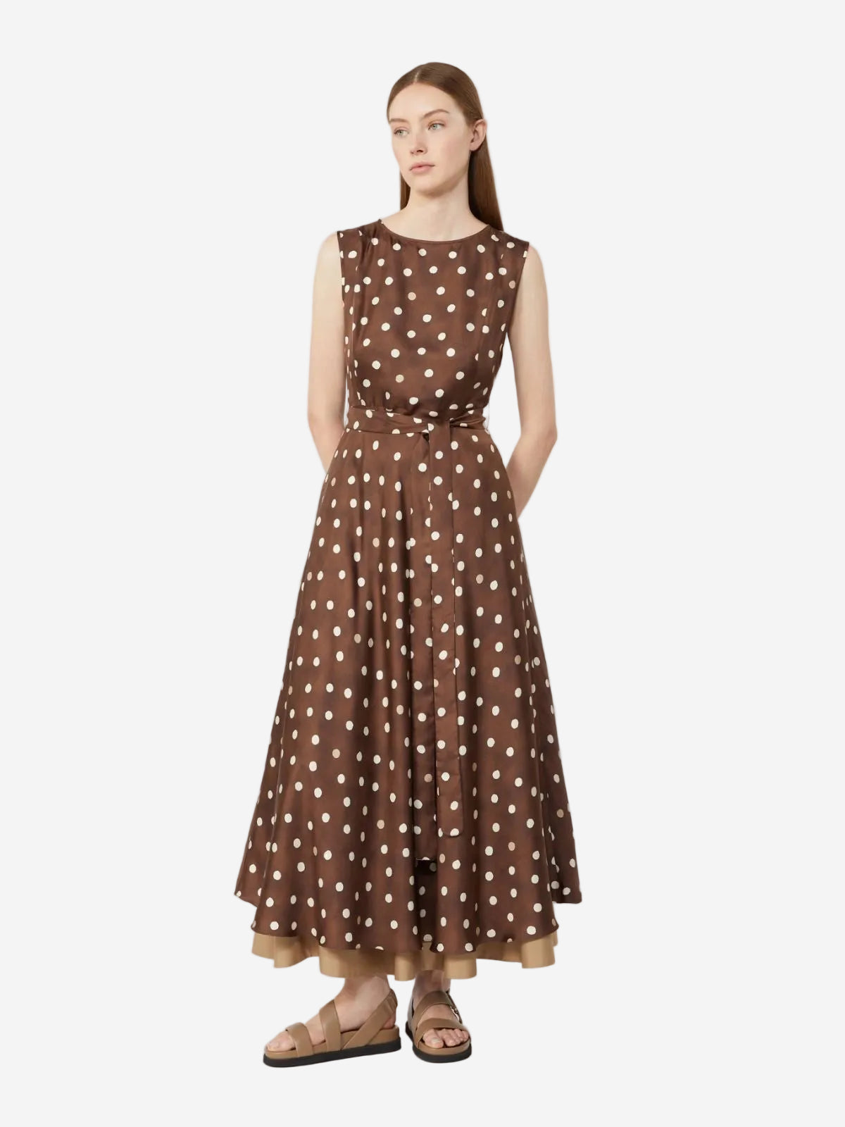 Woman wearing a brown polka dot dress on a white background