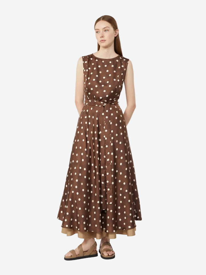 Woman wearing a brown polka dot dress on a white background
