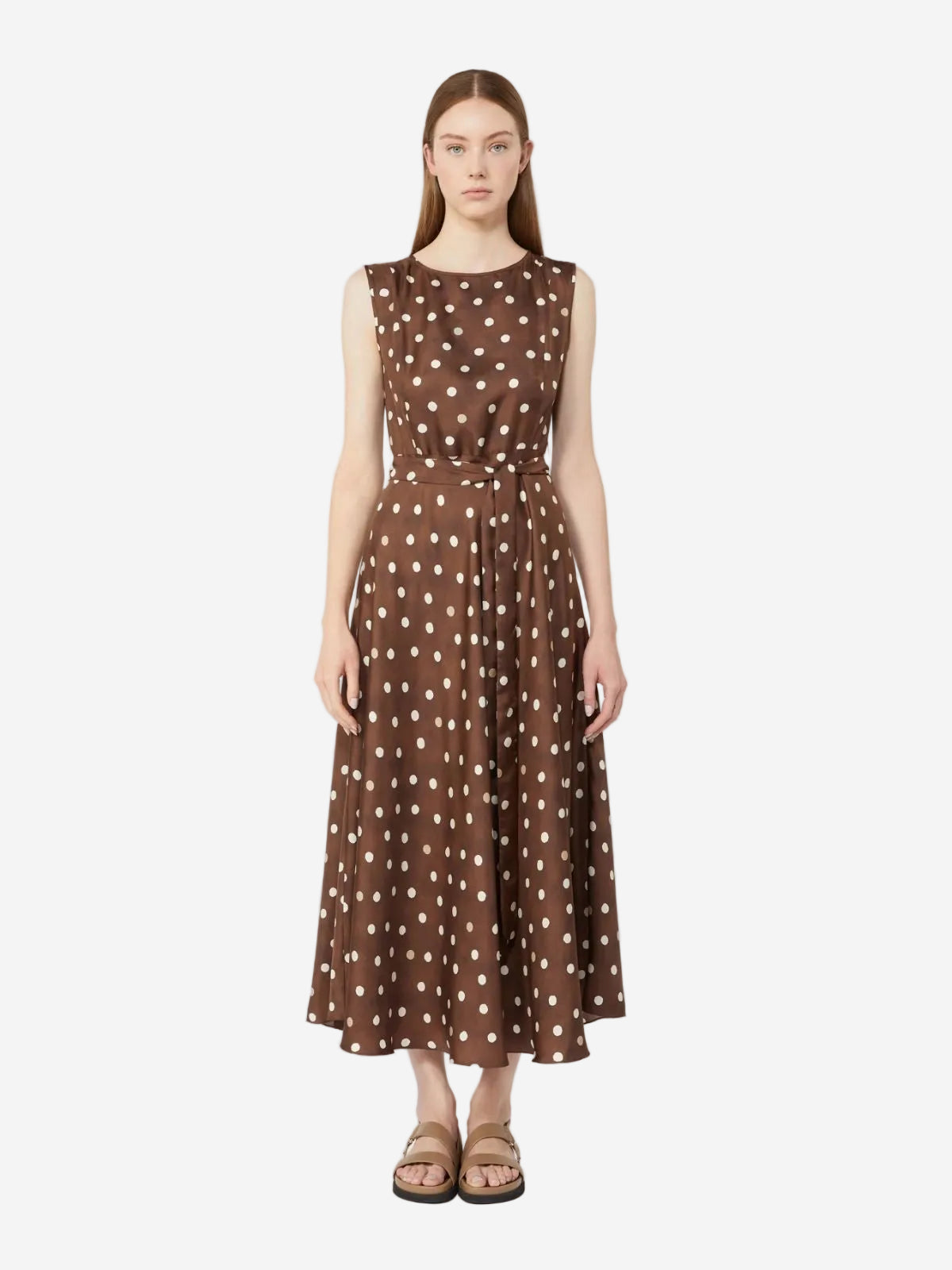 Woman wearing a brown polka dot dress on a white background