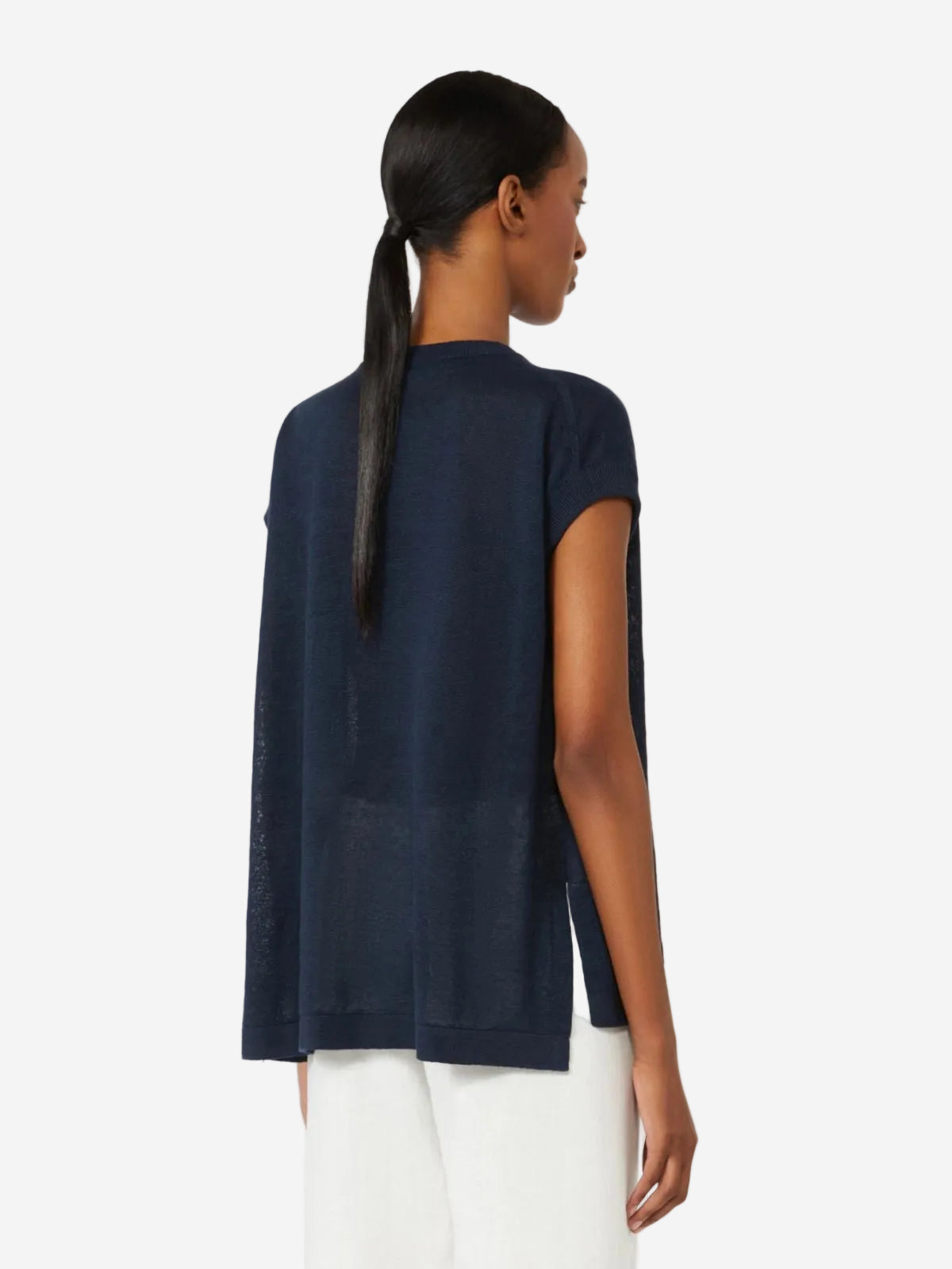 Woman wearing a navy blue sleeveless top with a plain white background