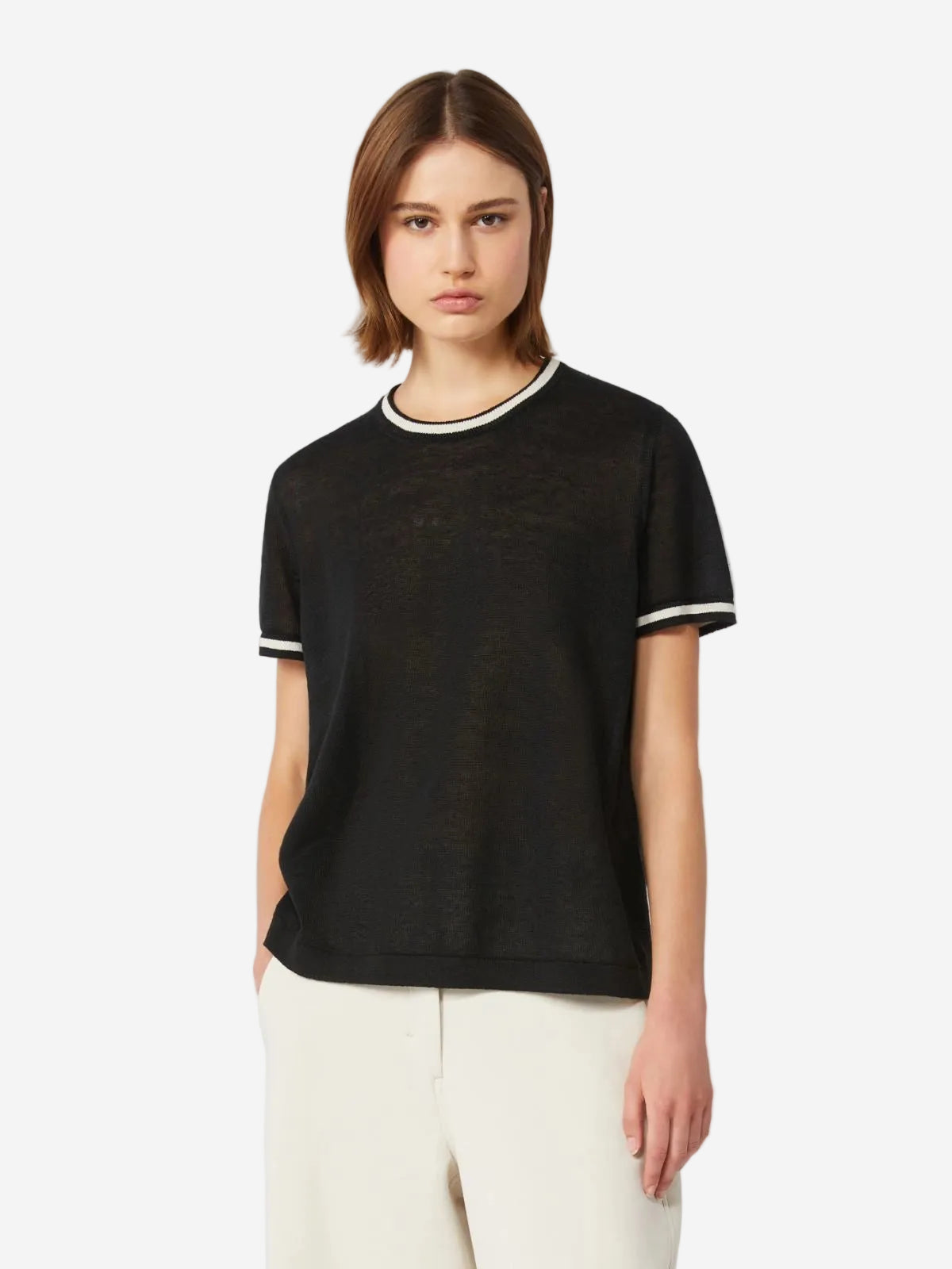 Woman wearing a black t-shirt with white trim on a light gray background