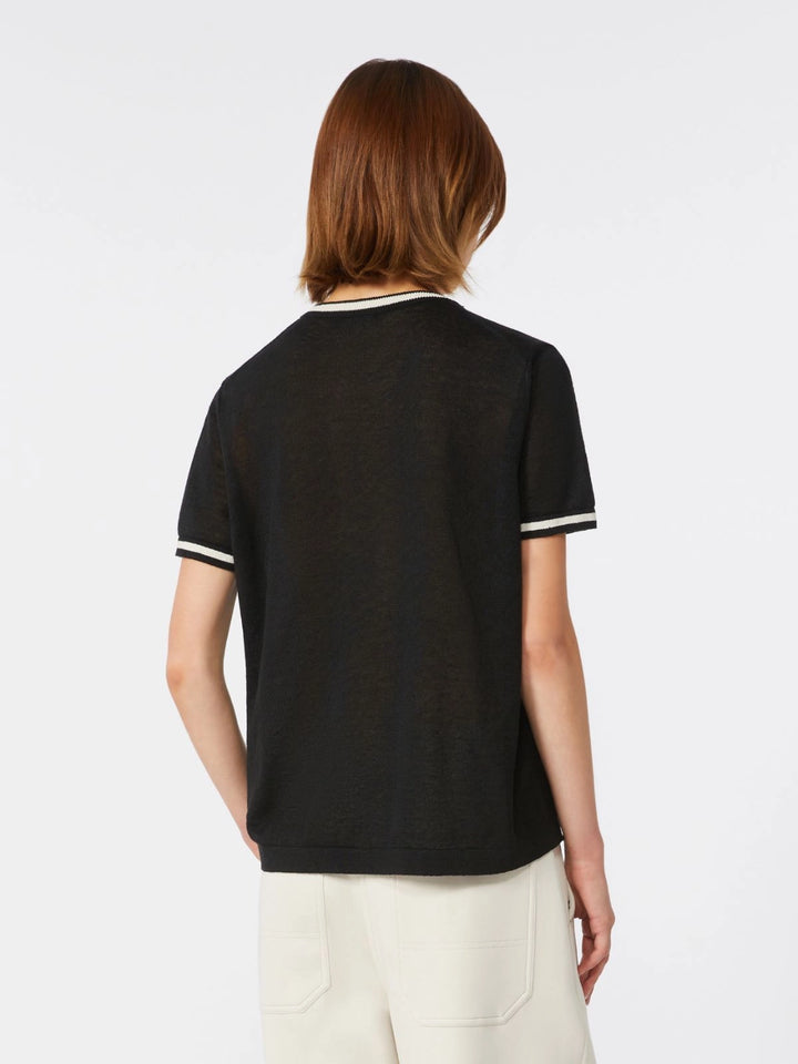 Person wearing a black t-shirt with white trim on a plain background