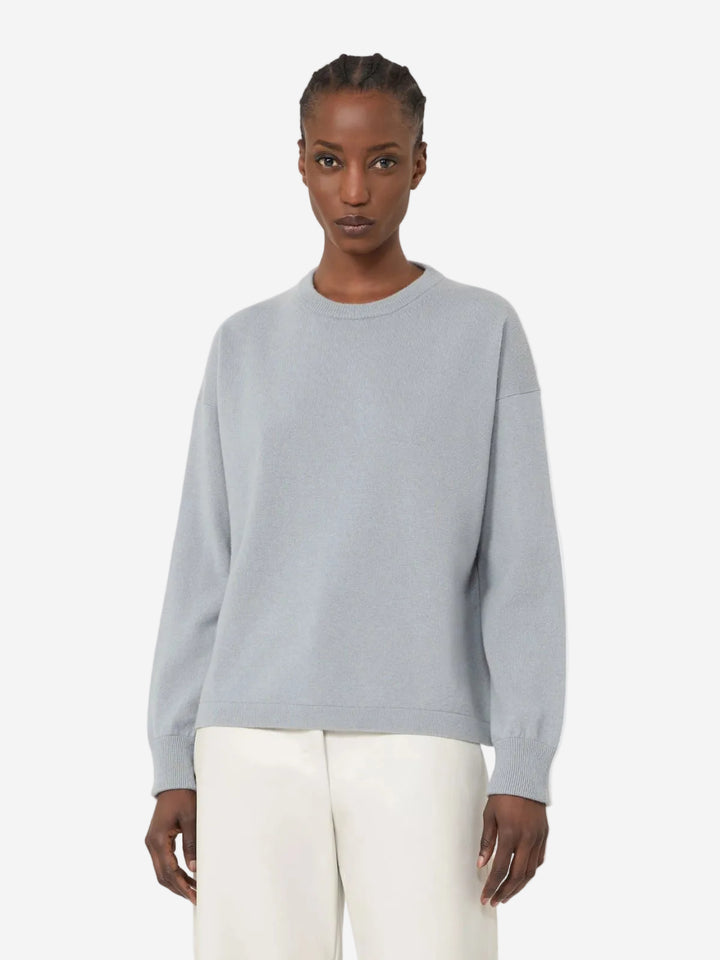 Person wearing a light gray sweater and white pants on a plain background, New Arrivals at Christensen Copenhagen