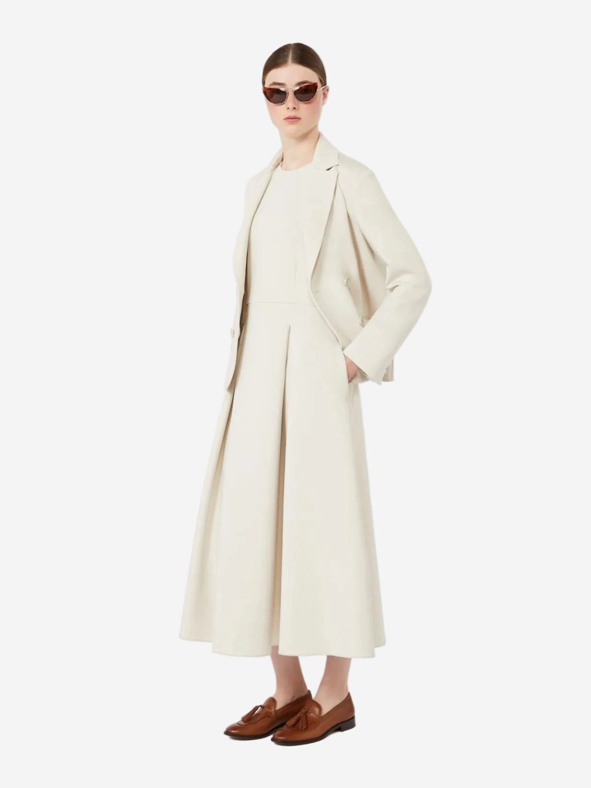 Woman wearing a long cream coat over a dress on a white background, New Arrivals to Christensen Copenhagen
