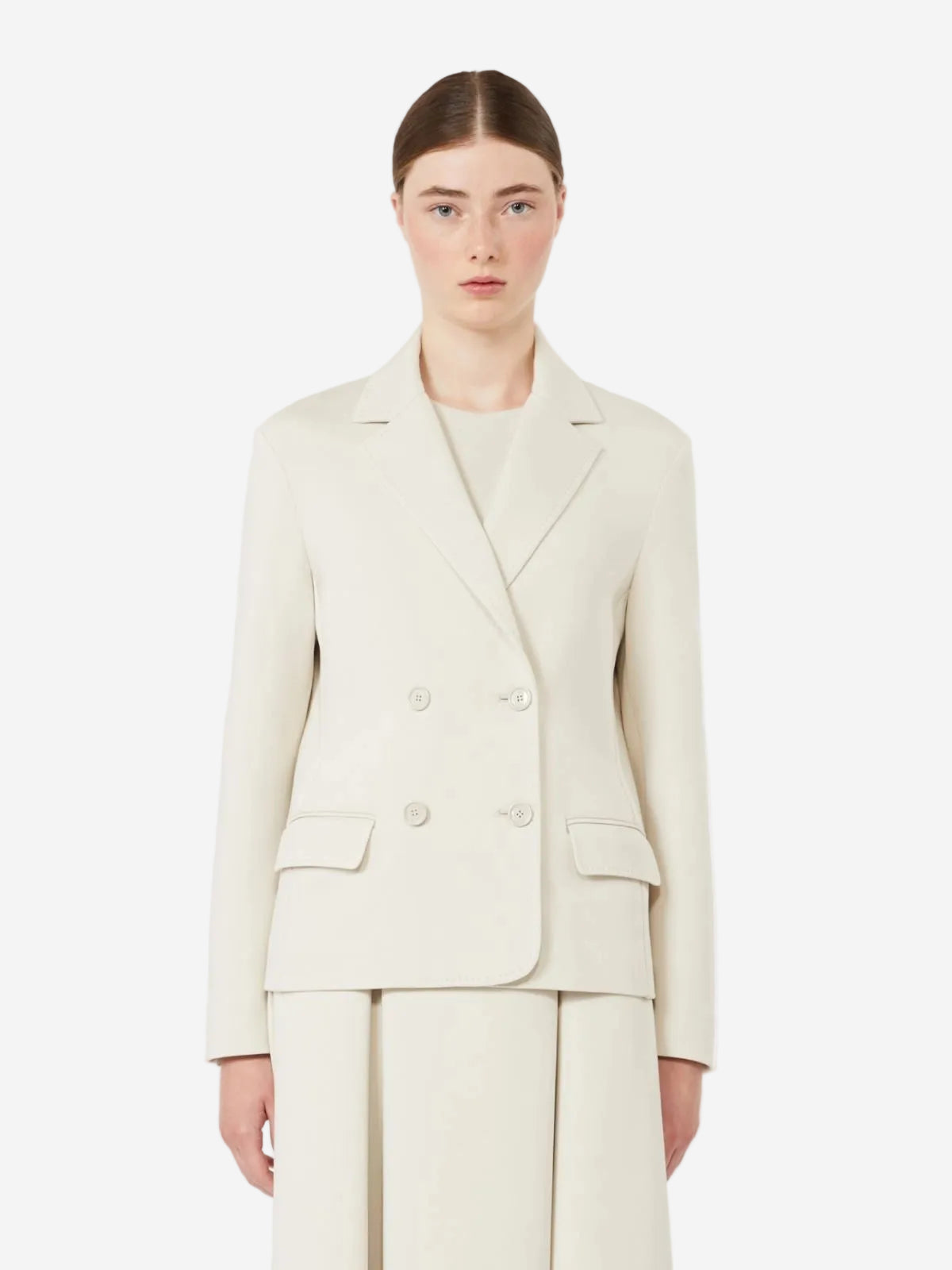 Woman wearing a cream-colored suit on a white background
