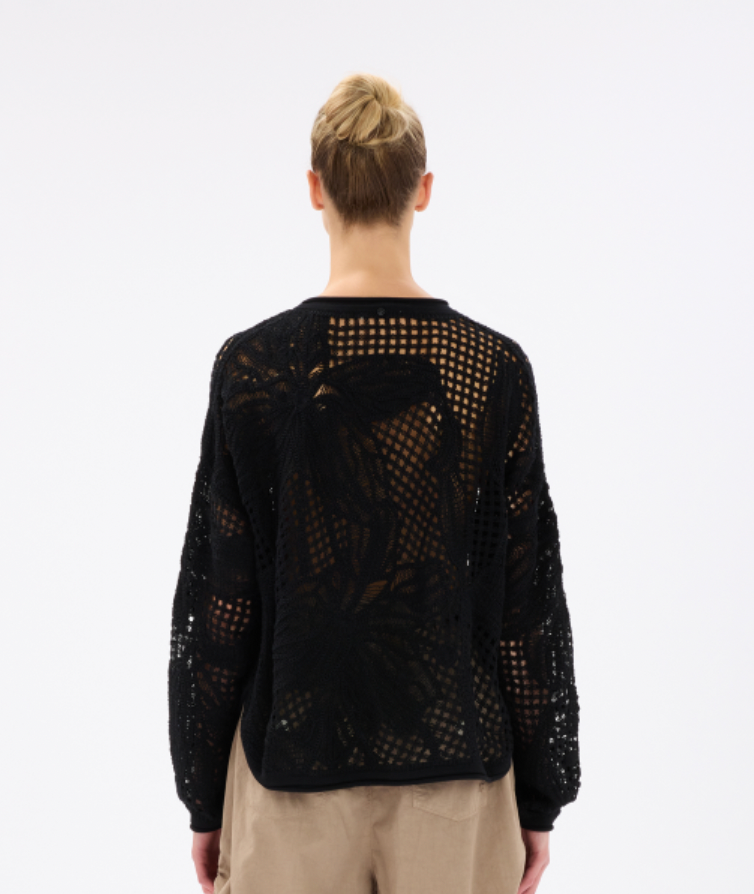 Person wearing a black mesh sweater on a white background