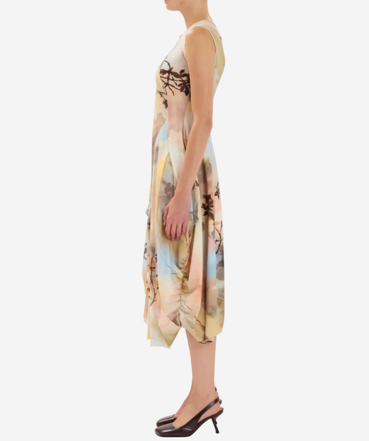 Woman wearing a sleeveless dress with a floral pattern on a white background