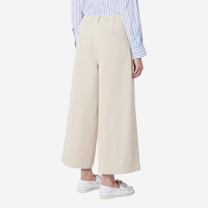 Person wearing beige wide-leg pants with a striped shirt on a white background