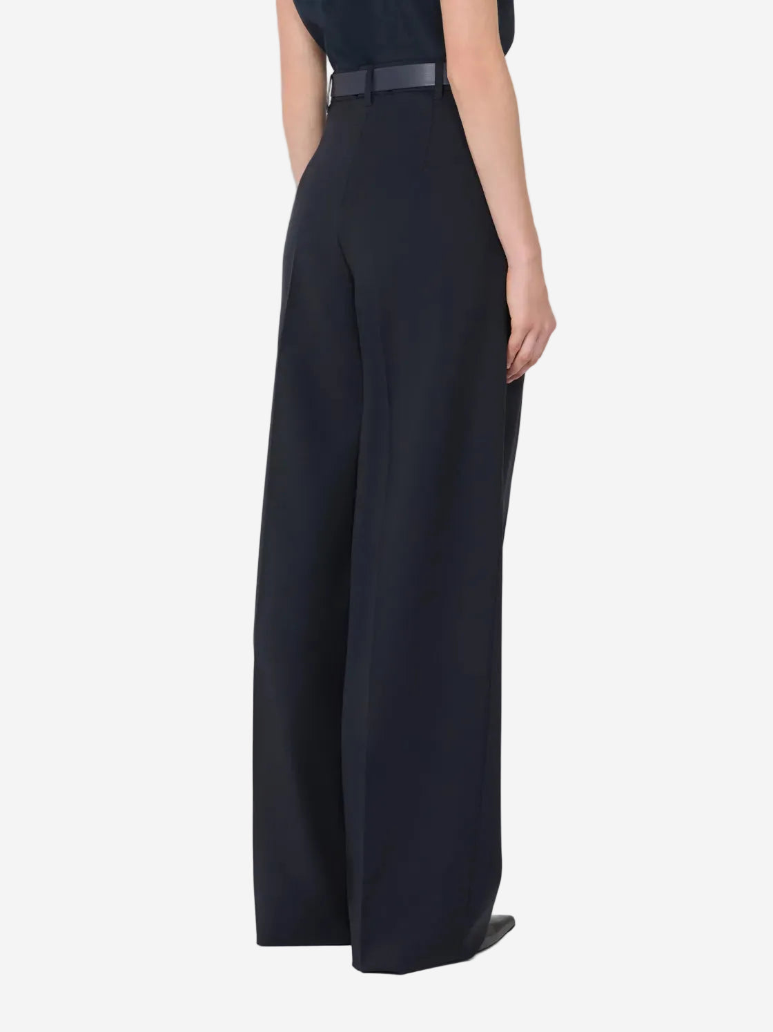 Person wearing a black outfit with wide-leg pants on a white background