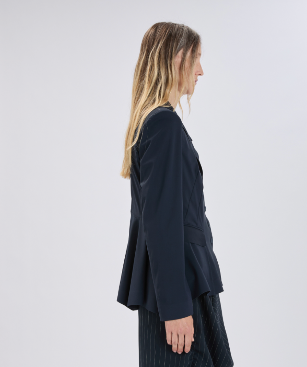 Woman wearing a dark blue blazer against a white background