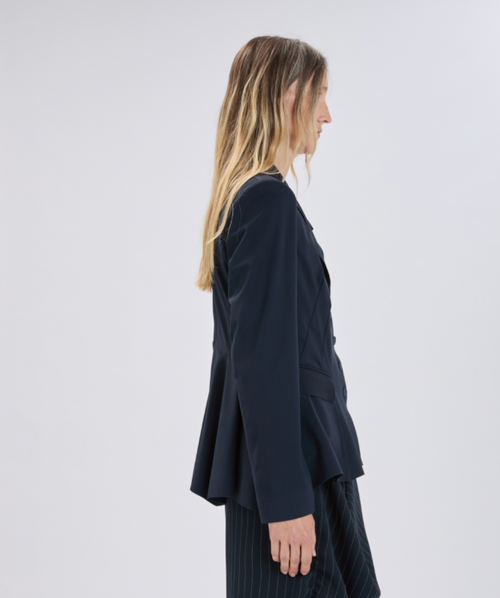 Woman wearing a dark blue blazer against a white background
