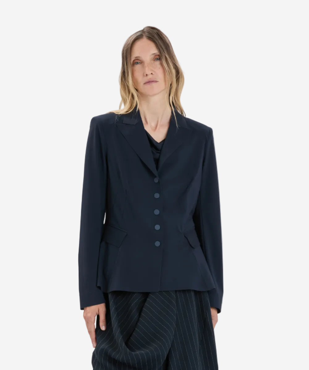 Woman wearing a dark blue suit against a white background