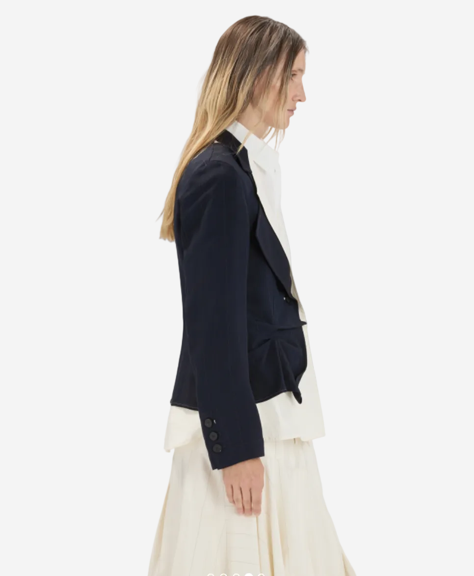 Woman wearing a black blazer over a white top on a white background