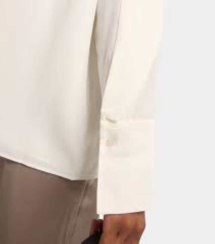 Close-up of a person wearing a white shirt with a blurred background