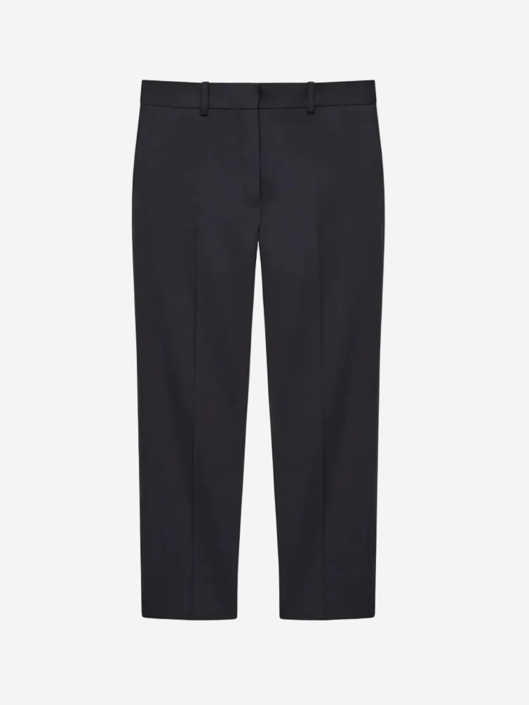 A pair of navy blue slim-fit trousers with cropped length and side pockets.