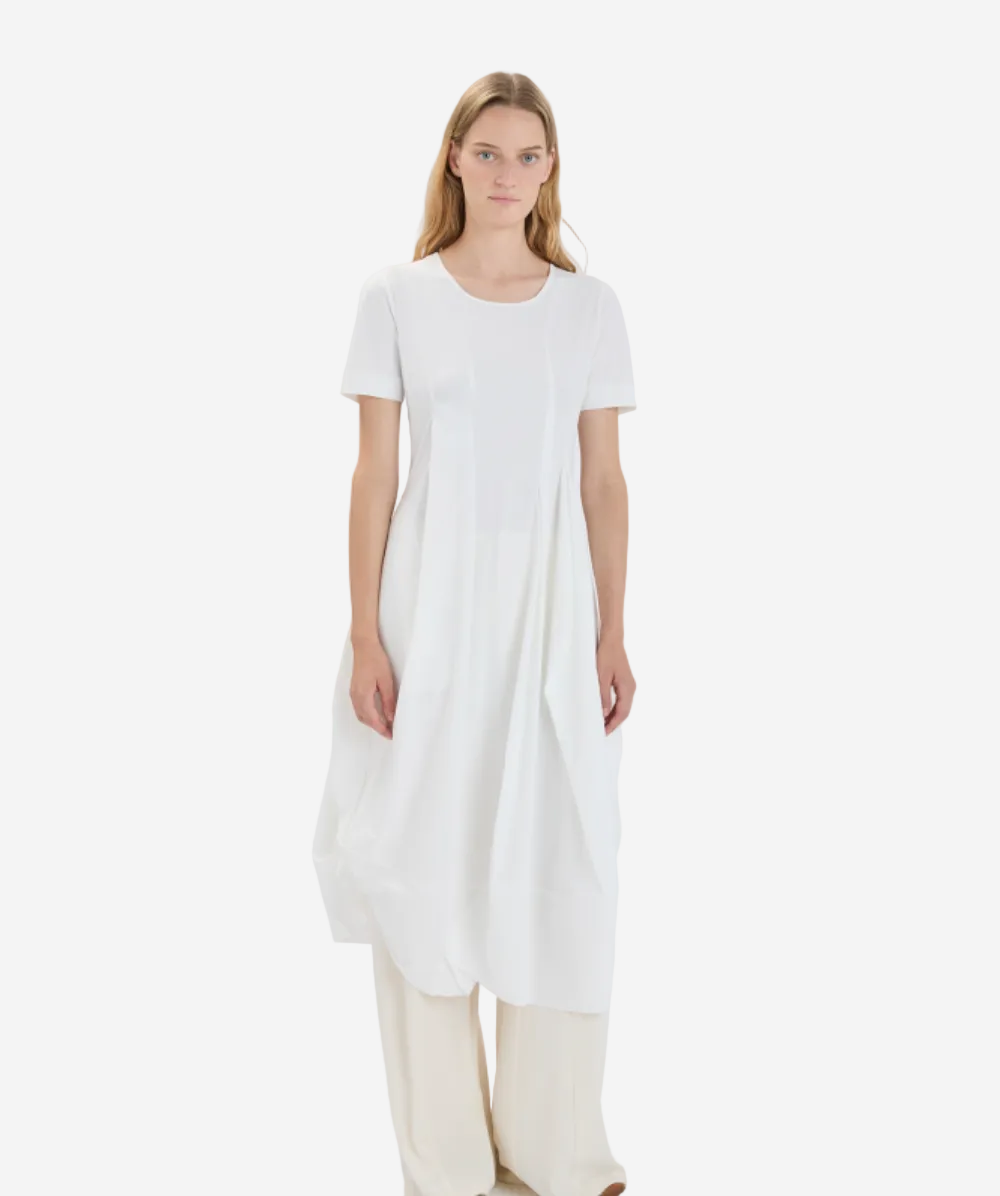 Woman wearing a white dress on a plain background