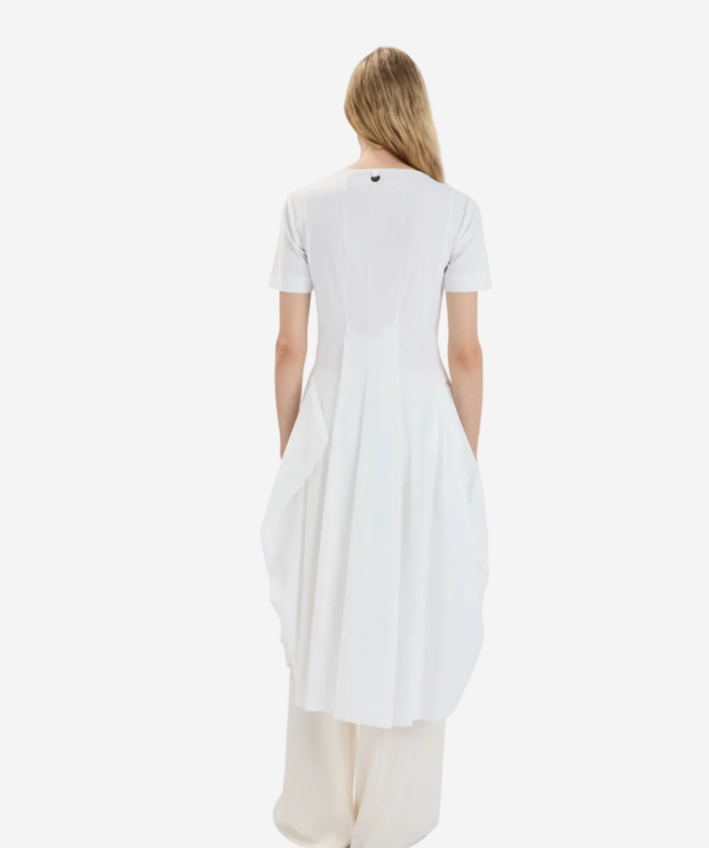 Woman wearing a white dress with cut-out sides on a light gray background
