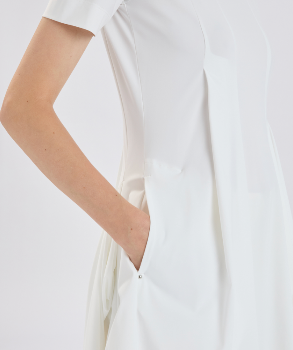 White dress worn by a person on a plain background