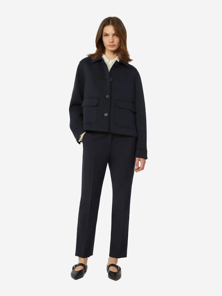 Woman wearing a navy blue jacket and pants on a white background