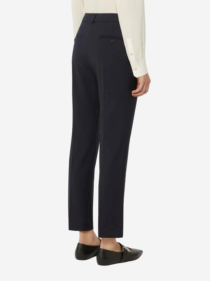 Person wearing navy pants on a white background