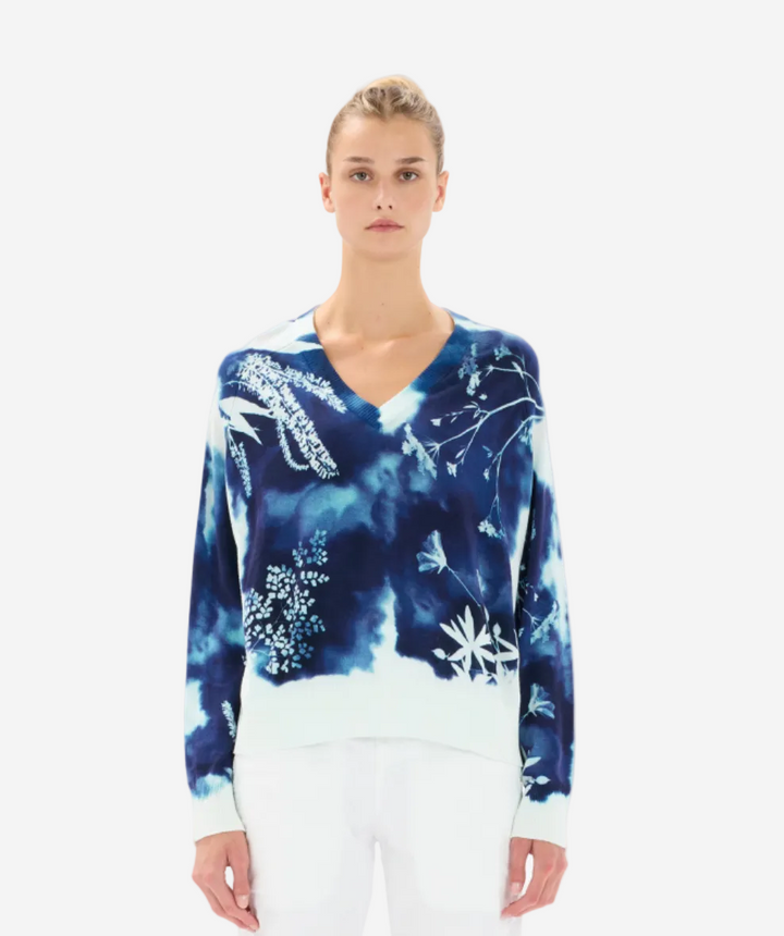 Woman wearing a blue floral-patterned sweater on a white background