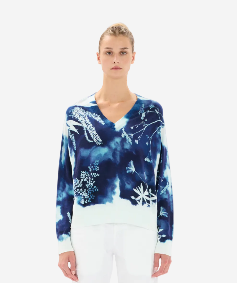 Woman wearing a blue floral-patterned sweater on a white background