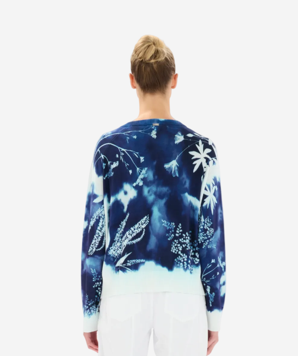 Person wearing a blue floral patterned sweater on a white background