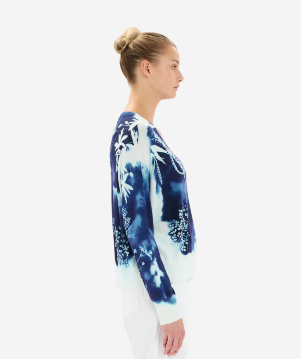 Woman wearing a blue and white tie-dye long-sleeve shirt on a white background