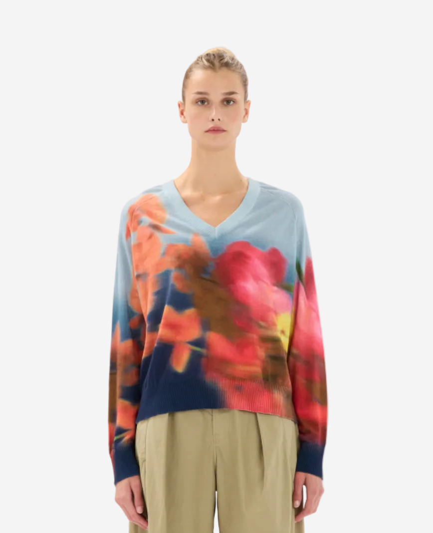 Woman wearing a colorful floral sweater on a white background