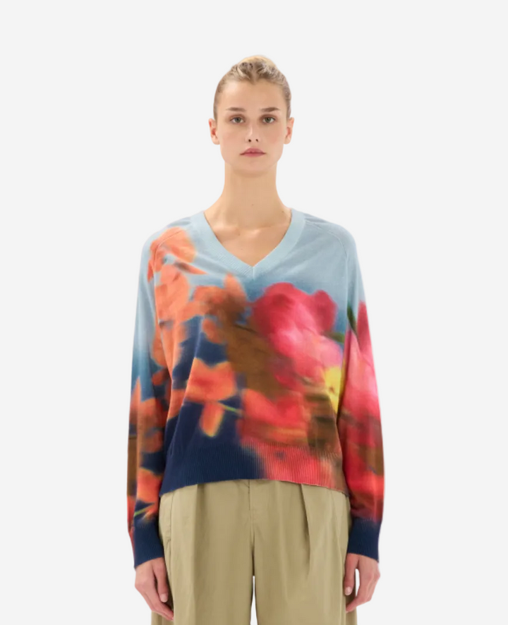 Woman wearing a colorful floral sweater on a white background
