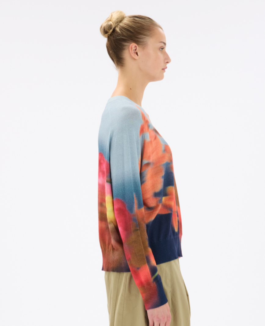 Woman wearing a colorful sweater with a white background