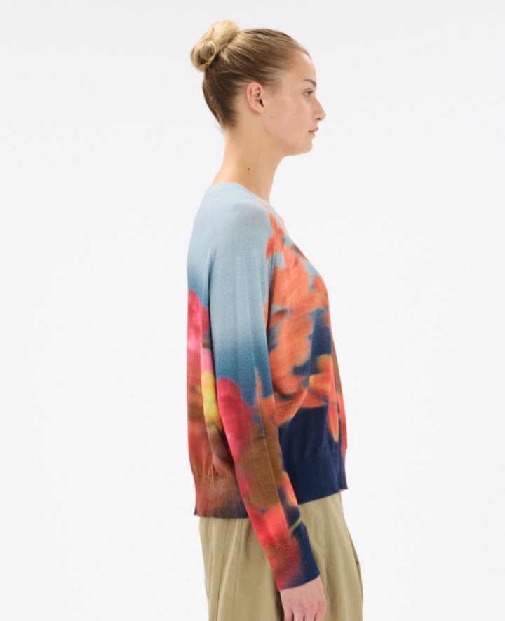 Woman wearing a colorful sweater with a white background