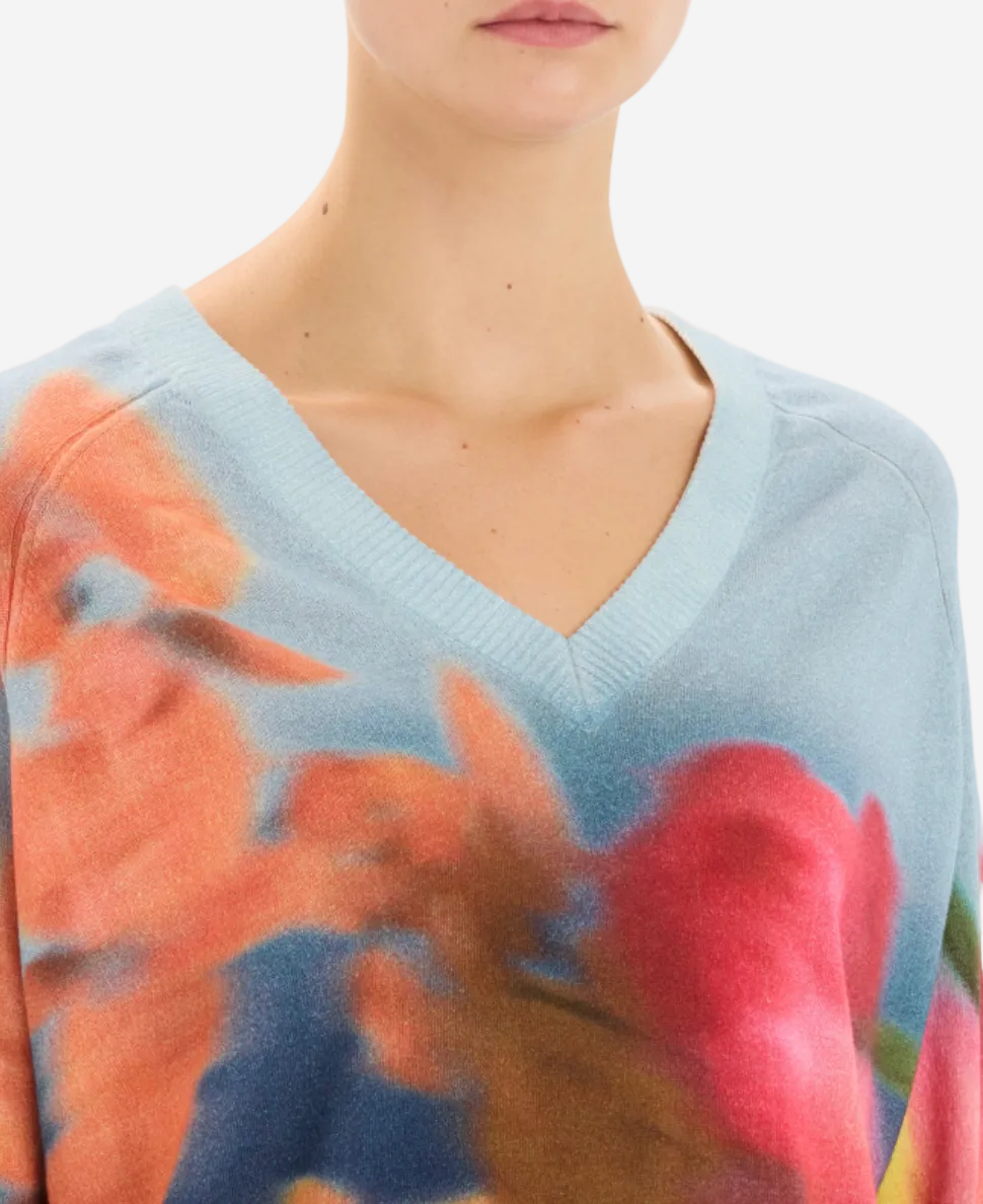 Light blue sweater with floral pattern worn by a person