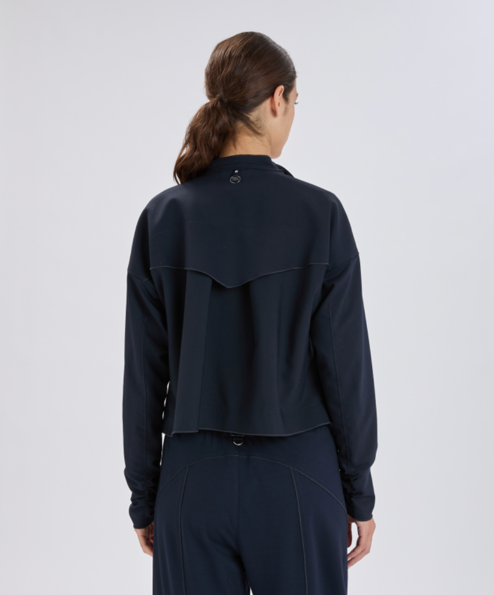Person wearing a dark blue jacket and pants on a white background