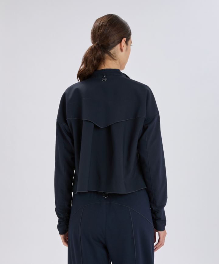 Person wearing a dark blue jacket and pants on a white background