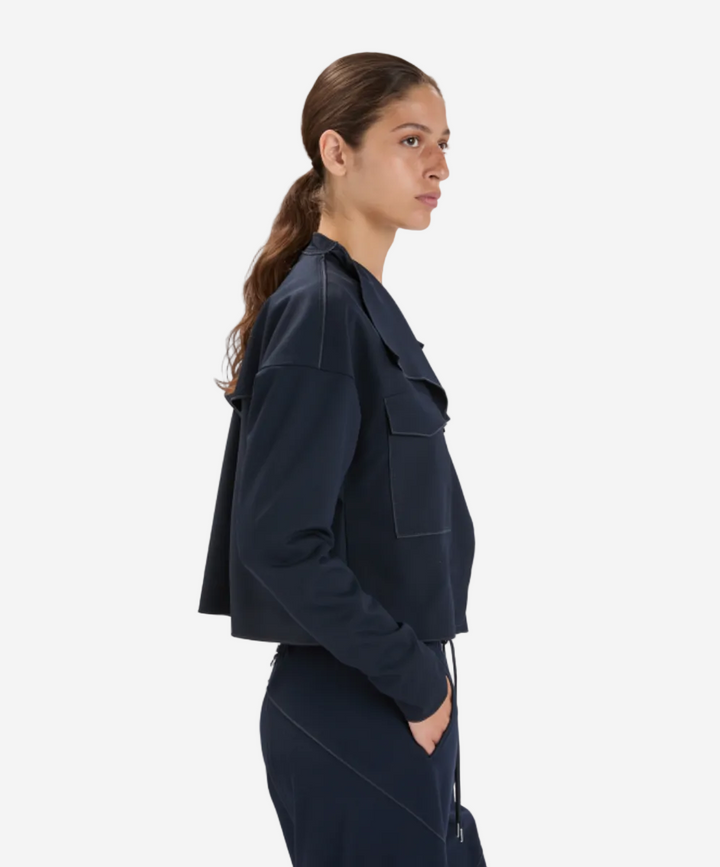 Woman wearing a dark blue jacket and pants on a white background