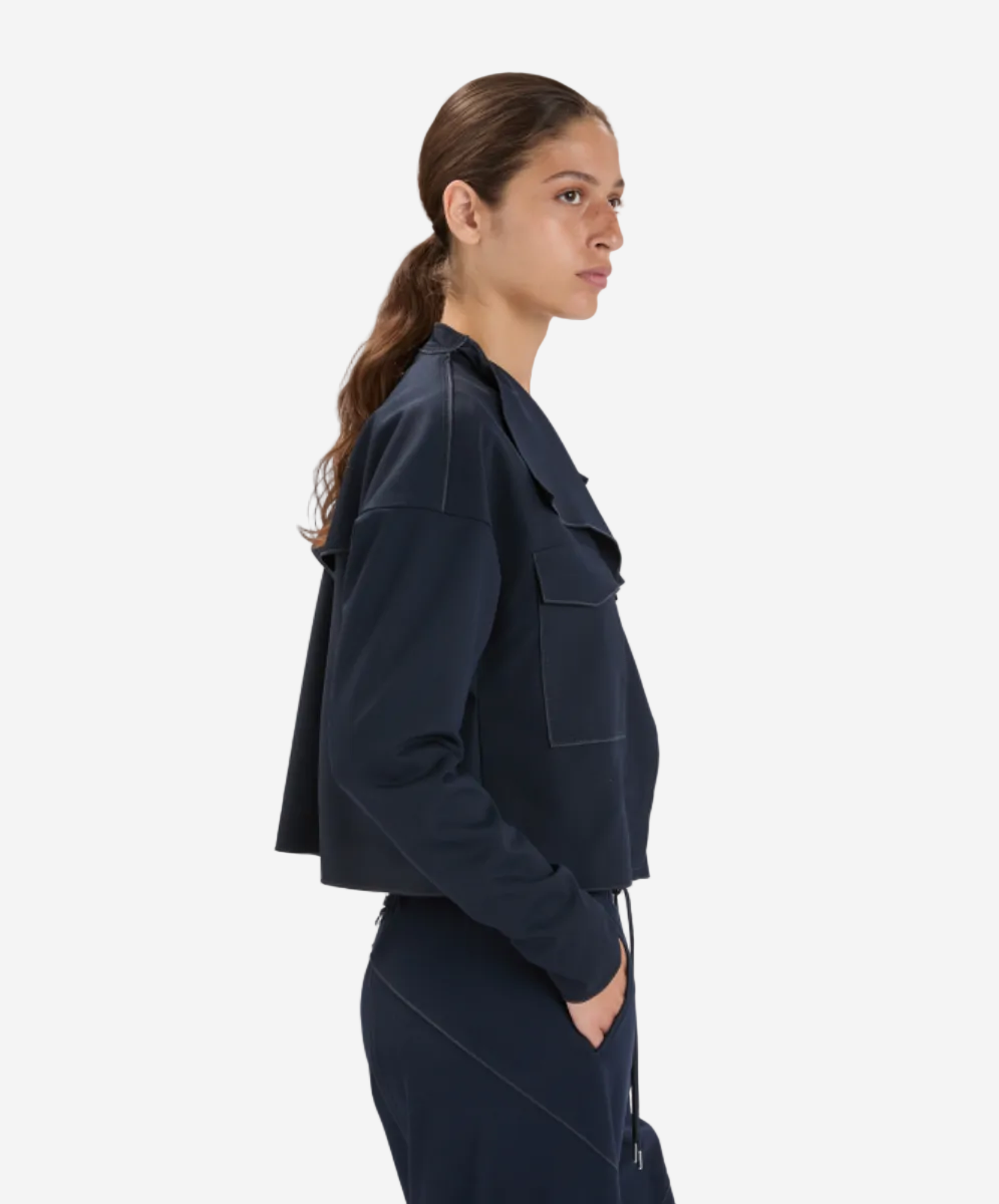 Woman wearing a dark blue jacket and pants on a white background