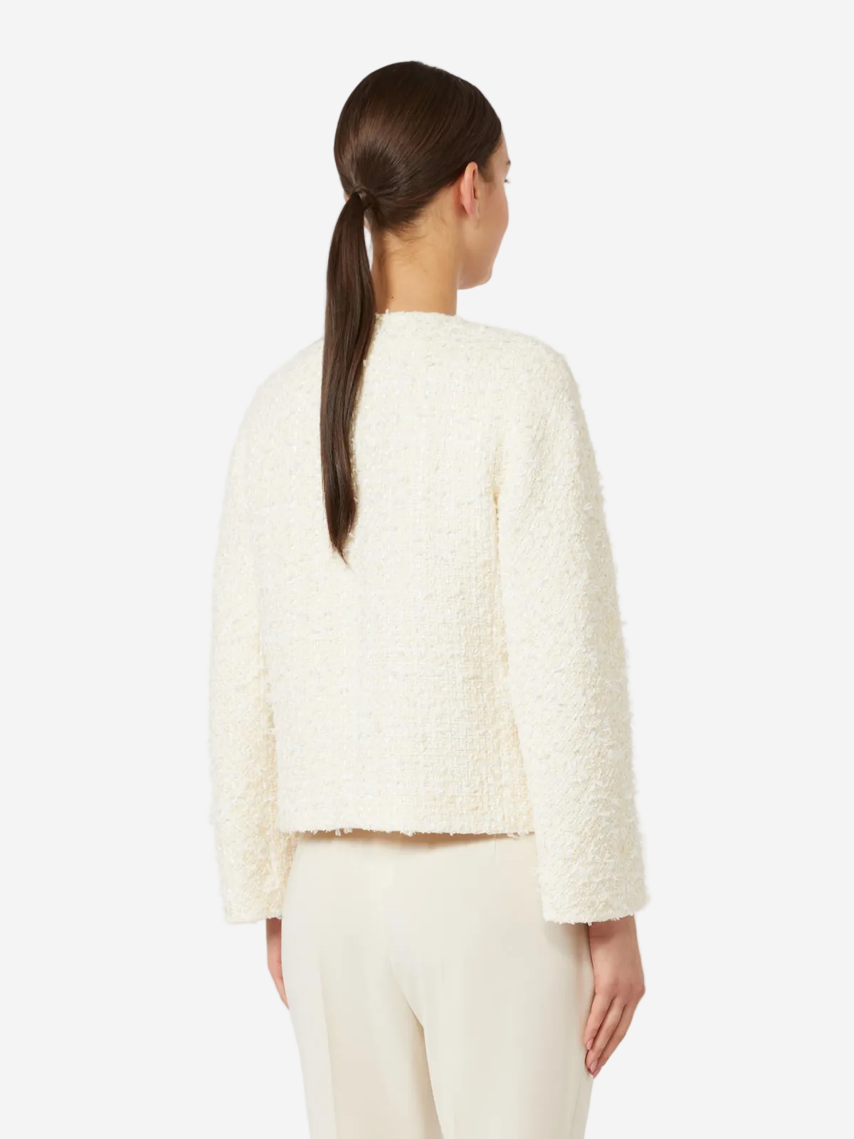 Woman wearing a cream-colored textured jacket on a white background