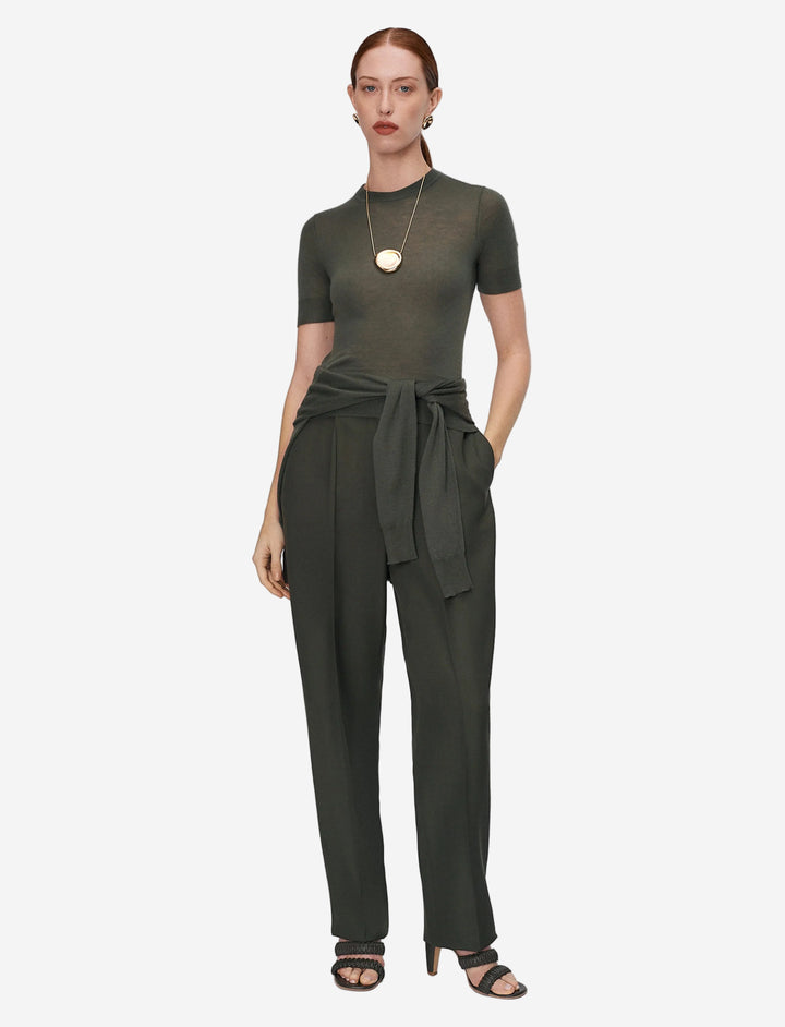 Woman wearing a green jumpsuit on a white background